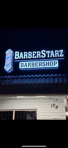 Lit BarberStarz Barbershop sign above the Tulare and Chestnut shop at 108 S Chestnut Ave in Fresno