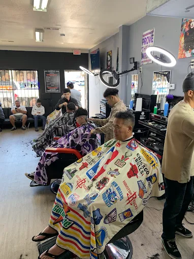Barbers cutting hair for clients at BarberStarz Barbershop Tulare and Chestnut in Fresno